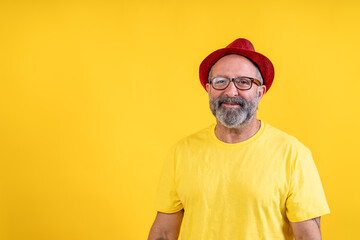 Smiling bearded man wearing red hat and yellow shirt