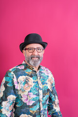 Smiling man wearing bowler hat and colorful shirt
