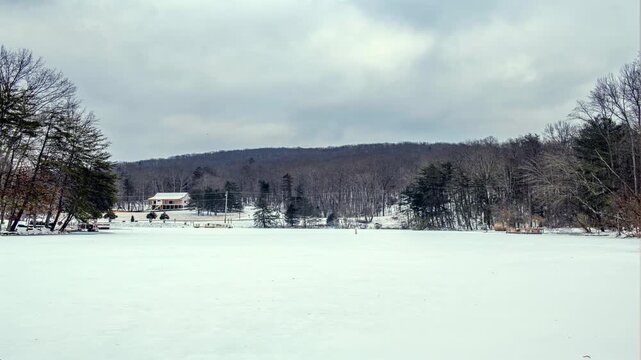 Timelapse of a snowy, frozen lake shows how the weather changes and affects the atmosphere of the surrounding area.