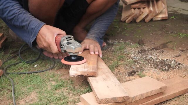 A scene of hand-made furniture being made using a hand grinder on a wooden board. The frame incorporates a side perspective to convey the realistic speed and laborious workmanship.