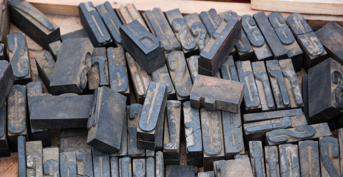 Old rusty English alphabet   letterpress and numbers printing blocks at flea market in Paris, France. Vintage background.