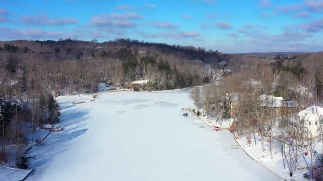 Beautiful Lake Dartmoor in Tennessee shown frozen with white, powdery snow on top during a bright winter day.