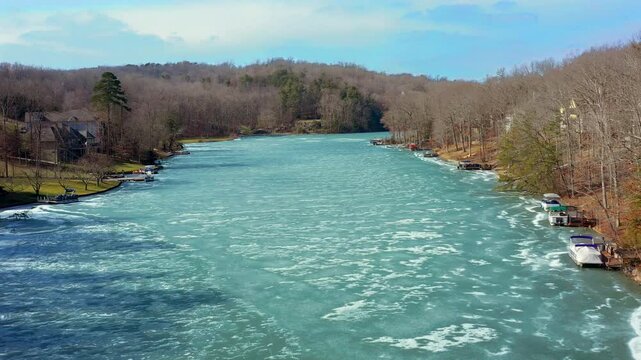Beautiful Lake Dartmoor in Tennessee shown frozen with white, patchy snow on top during a bright winter day.