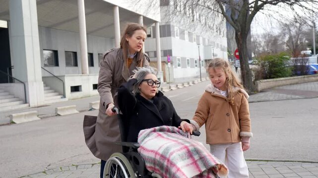 Three generations of a family enjoying a walk outside a hospital