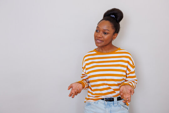 Young woman actively speaking and gesturing, communicating ideas with expressive body language and open hands