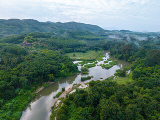 Aerial view river canal in tropical rainforest green tree mountain with fog © themorningglory