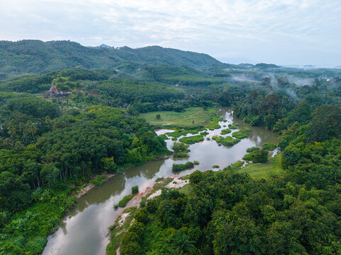 Aerial view river canal in tropical rainforest green tree mountain with fog