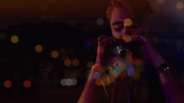 Animation on blurred night road traffic over caucasian man playing harmonica on concert