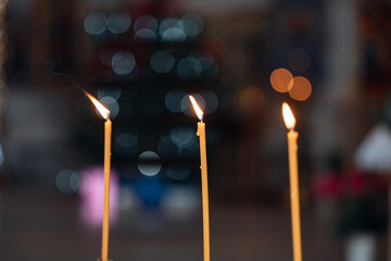 Candle flames in a church setting during a religious ceremony