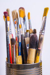 Fototapeta premium Various paintbrushes collected in a can for use in art projects and creative activities at a studio setting during the day