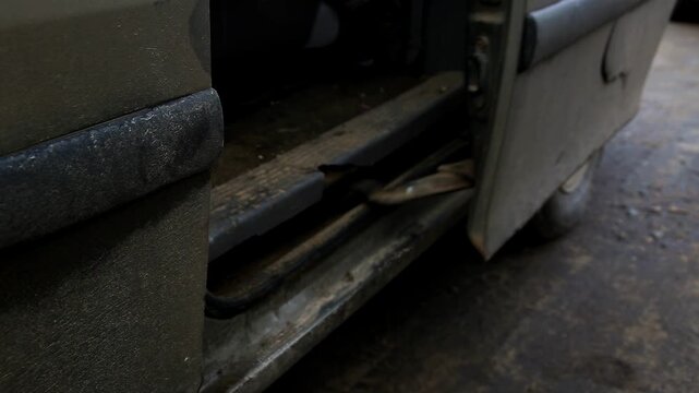 Dirty old car door opening and closing. Rusty door sill and worn interior of utility vehicle visible. Grimy exterior of panel van shows clear signs of neglect, deterioration, and age.