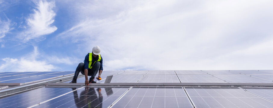 Engineer service check installation solar cell on the roof of factory. Engineers walking on roof inspect and check solar cell panel. Engineer working inspection installation solar cell on the roof