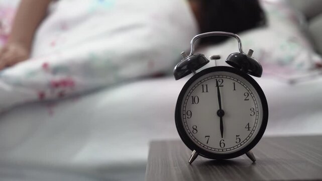 Black Vintage Alarm Clock Ringing at 6 AM with Person Waking Up in Background