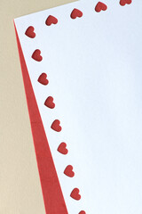 blank paper with heart border on red and beige paper background