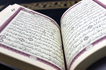 Fototapeta premium Holy Quran open on a prayer rug in a mosque - Islamic concept A high-quality close-up of the Holy Quran pages, placed on a traditional blue prayer rug inside a mosque. 