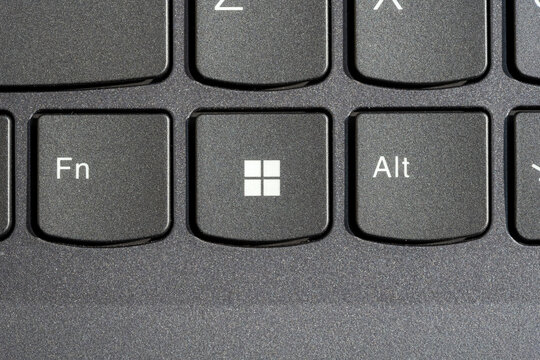 Windows key on modern laptop keyboard, macro detail top view of Microsoft logo button between Fn Alt keys, black textured keys closeup operating system upgrade update concept computer shortcut control