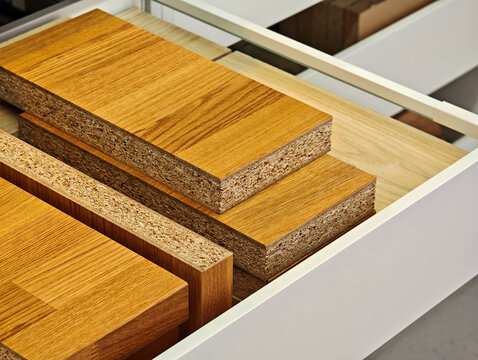 MDF wood material samples in a furniture store drawer display, chipboard particle board panels with oak veneer texture, carpentry interior design selection, cabinetry manufacturing, DIY concept