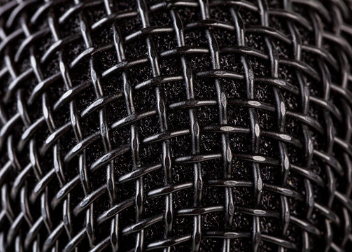 Abstract black microphone grille mesh macro texture, extreme closeup of metal wire weave and foam windscreen, full frame background pattern for audio, music, podcast, studio recording design wallpaper
