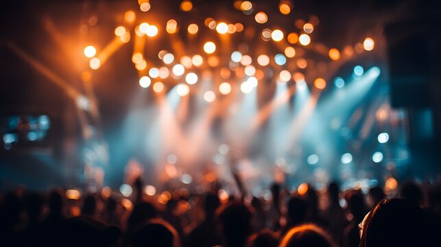 Blurry image of a lively concert with bright stage lights shining down on the crowd of people at a music festival or live event