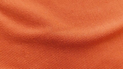 Obraz premium Close up of soft orange sports clothing fabric. Football jersey textile texture background. Orange sports wear background with fabric detail.