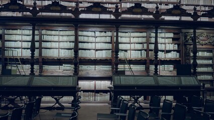 Historic library interior showing rows of ornate wooden bookcases and detailed sharp wood texture on shelves and desks under soft ambient light  background backplate copyspace template. © Krakenimages.com