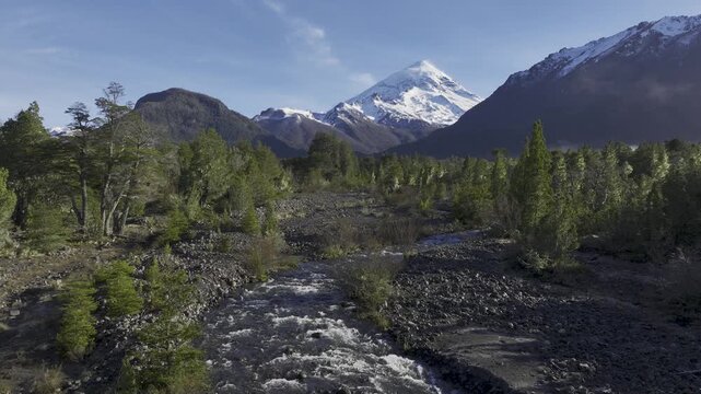 Vivid Landscape of Snow Capped Lanin Volcano Above Rocky Riverbed and Forest. Lanin National Park, Argentina