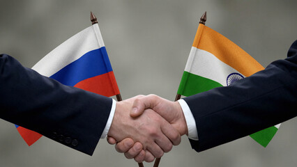 Businessmen shaking hands with Russian and Indian flags behind