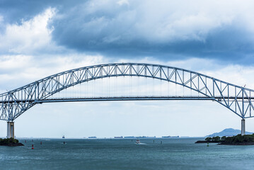 Obraz premium Bridge of the Americas spanning the Pacific entrance to the Panama Canal under overcast sky.
