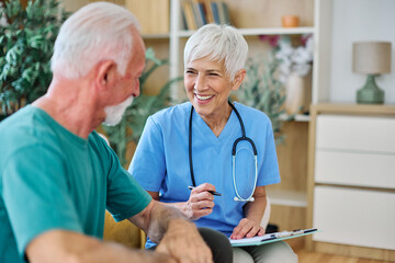 Portrait of a senior doctor or nurse caregiver talking consultation with senior man at home or...