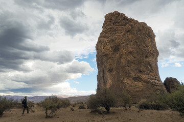 Hiker looking at Piedra Parada huge tall rock formation. Chubut, Argentina