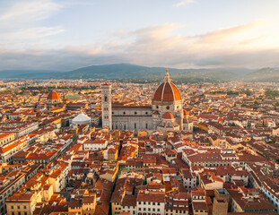 Obraz premium Golden light aerial view of Florence showcasing the Duomo cathedral and historic skyline under warm evening tones in Florence, Italy