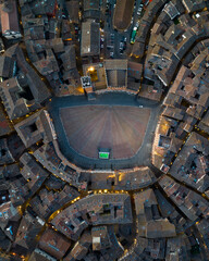Obraz premium Vertical top down aerial view of Piazza del Campo, the famous shell-shaped medieval square in Siena, Tuscany. Unique urban design and historic architecture seen from above