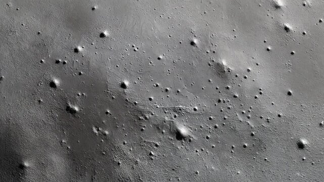 Abstract view of a surface with craters and subtle textures. The surface has a rough and textured appearance with the presence of multiple circular craters.
