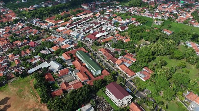 Aerial View of Dense Residential Area in Indonesia with Red Tile Roofs and Clear Blue Sky