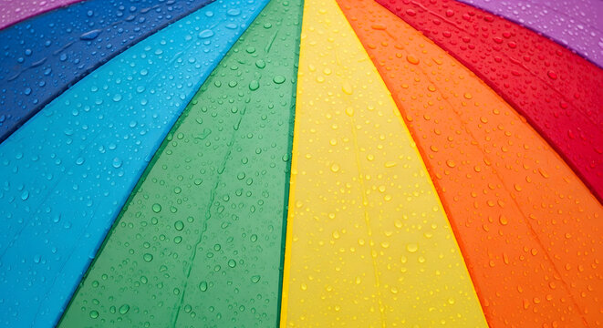 Vibrant rainbow umbrella with raindrops on colorful surface