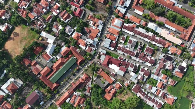 Aerial View of Dense Residential Area in Indonesia with Red Tile Roofs and Clear Blue Sky
