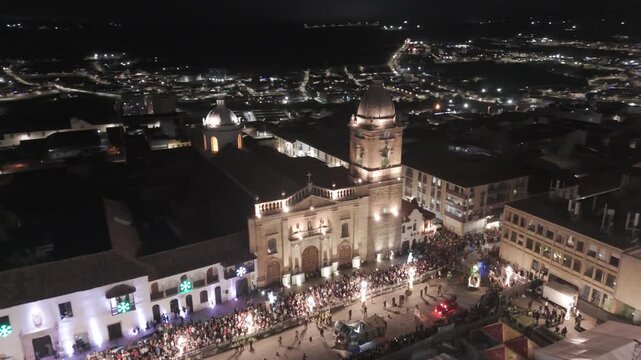 Drone view of illuminated parade float next to church at night