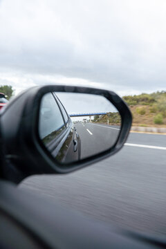 A car is driving down a road with a blue sky in the background