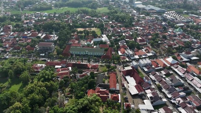Aerial View of Dense Residential Area in Indonesia with Red Tile Roofs and Clear Blue Sky
