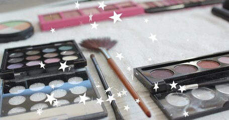 Displaying open eyeshadow palettes and fan and slim brushes on vanity towel, showing star overlay