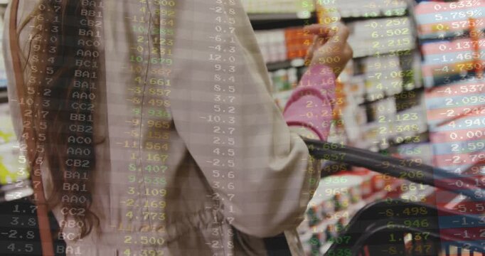Woman holding basket, reaching, grabbing pink item in retail aisle, reading label, code overlaying