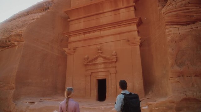 Visiting Hegra in AlUla, tourists explore ancient tombs in Saudi Arabia. Discovering Arabic culture