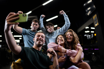 Obraz na płótnie Canvas Friends take a selfie at a fitness center during a group workout session enjoying exercise and each others company