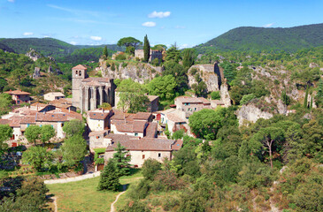Village de Mour&egrave;ze avec ses maisons group&eacute;es autour de l'&eacute;glise et du rocher.