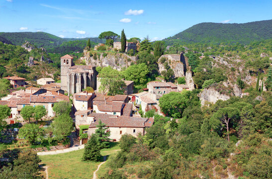 Village de Mour&egrave;ze avec ses maisons group&eacute;es autour de l'&eacute;glise et du rocher.