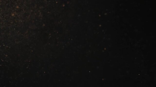 Ash particles drifting in dark space, slow motion abstract