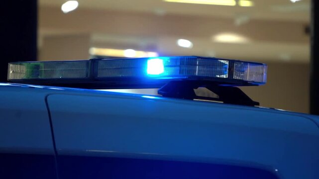 Close-up video of flashing emergency service lights at night. Intense blue and red signals create abstract reflections and motion blur, conveying urgency, alert, and public safety atmosphere.
