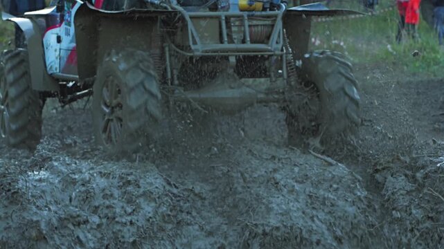 Dynamic close-up of a powerful off-road vehicle driving at high speed through deep mud. The action-packed scene captures a huge splash, showing a powerful, adventurous, and extreme motorsport