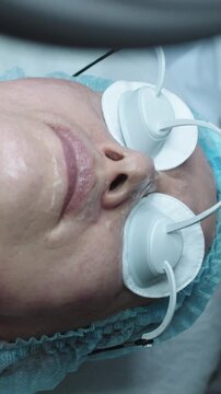 Cosmetology treatment - applying moisture on the skin of adult woman