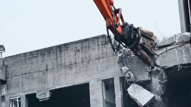 Concrete Pulverizer Crushing Reinforced Concrete During Building Demolition. Huge Demolition Shear in 4K Slow Motion Shot.